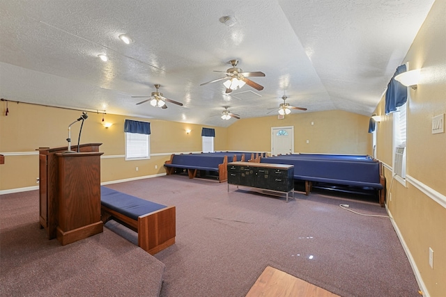 interior space with carpet floors, a textured ceiling, vaulted ceiling, and ceiling fan