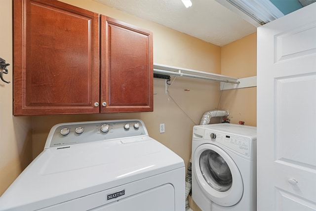 clothes washing area with independent washer and dryer and cabinets