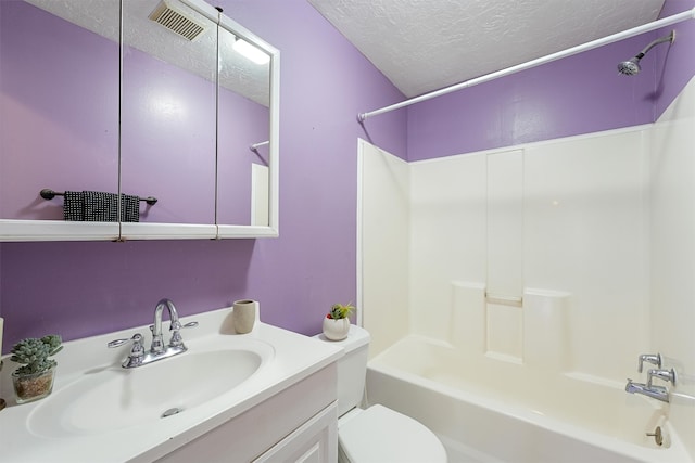 full bathroom featuring vanity, a textured ceiling, bathtub / shower combination, and toilet