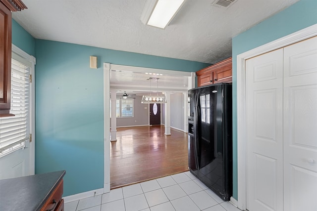 kitchen featuring ceiling fan, light hardwood / wood-style floors, black refrigerator with ice dispenser, pendant lighting, and a textured ceiling