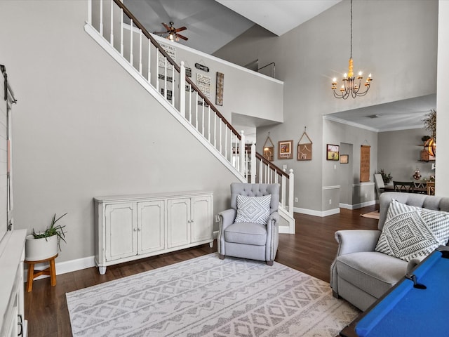 living area featuring a towering ceiling, dark wood-style floors, stairs, and baseboards