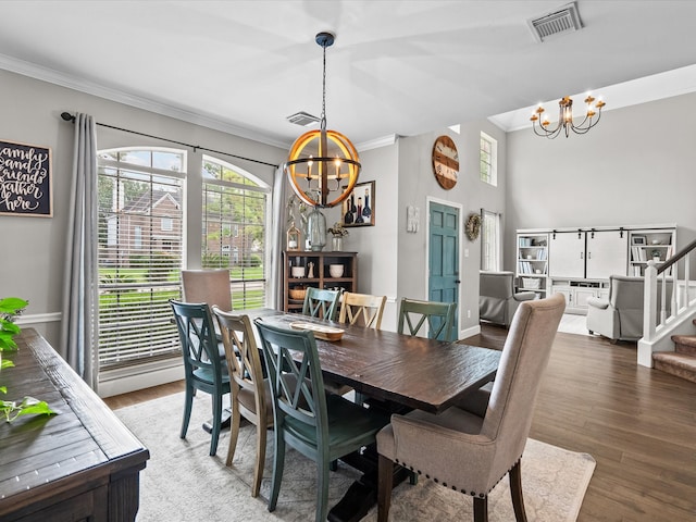 dining area featuring a chandelier, visible vents, crown molding, and stairs