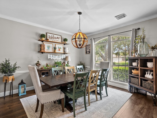 dining room with crown molding, visible vents, and wood finished floors