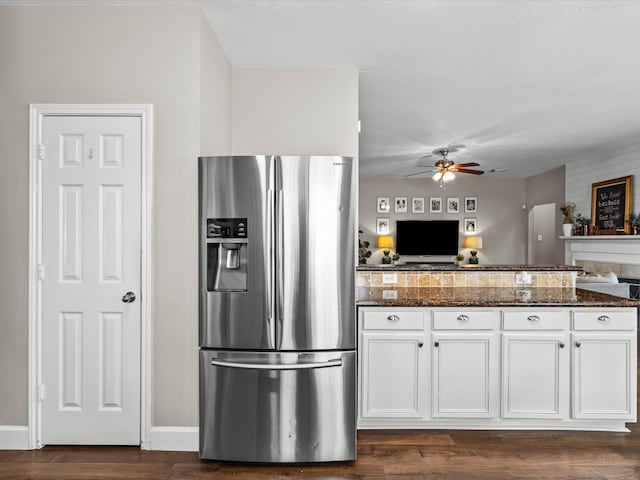 kitchen with dark wood-style flooring, white cabinets, ceiling fan, dark stone counters, and stainless steel fridge