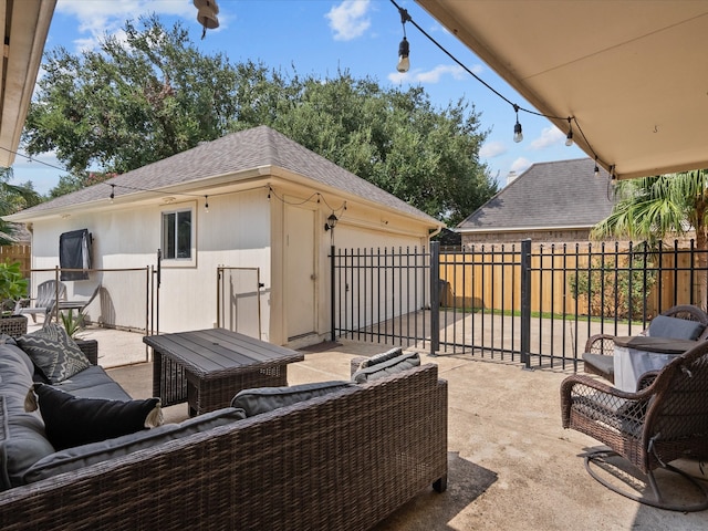 view of patio / terrace with a garage, fence, an outdoor living space, and an outdoor structure