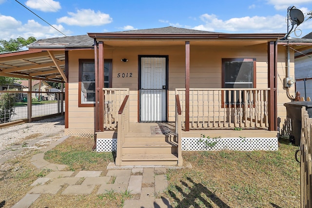 bungalow with covered porch and a carport