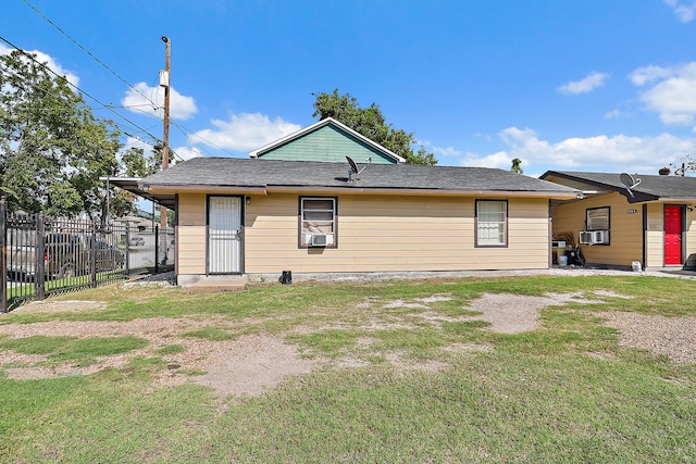 rear view of property featuring cooling unit and a yard