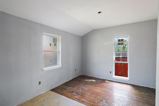 spare room with lofted ceiling and dark wood-type flooring