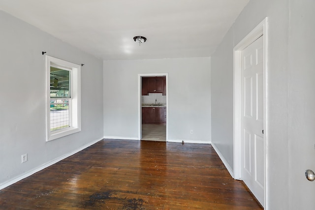 unfurnished room featuring sink and dark wood-type flooring