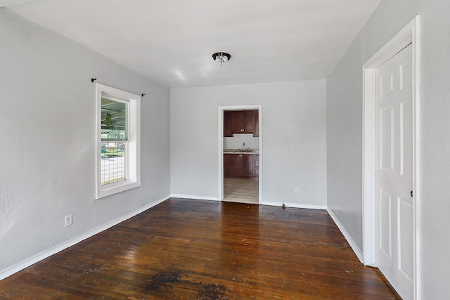 unfurnished room with sink and dark wood-type flooring