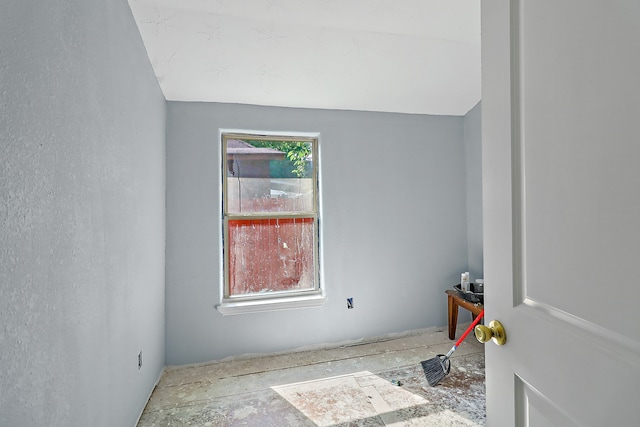 empty room featuring lofted ceiling