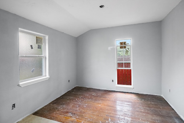 spare room with lofted ceiling and dark wood-type flooring