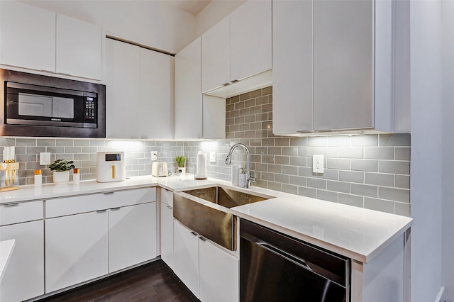 kitchen with appliances with stainless steel finishes, dark hardwood / wood-style floors, tasteful backsplash, and white cabinetry