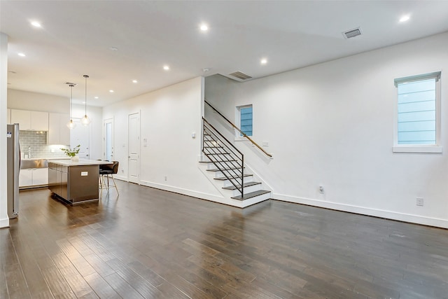 unfurnished living room with dark hardwood / wood-style floors and sink