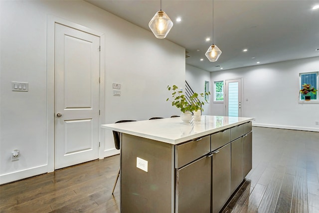 kitchen featuring pendant lighting, a breakfast bar, dark hardwood / wood-style floors, and a kitchen island