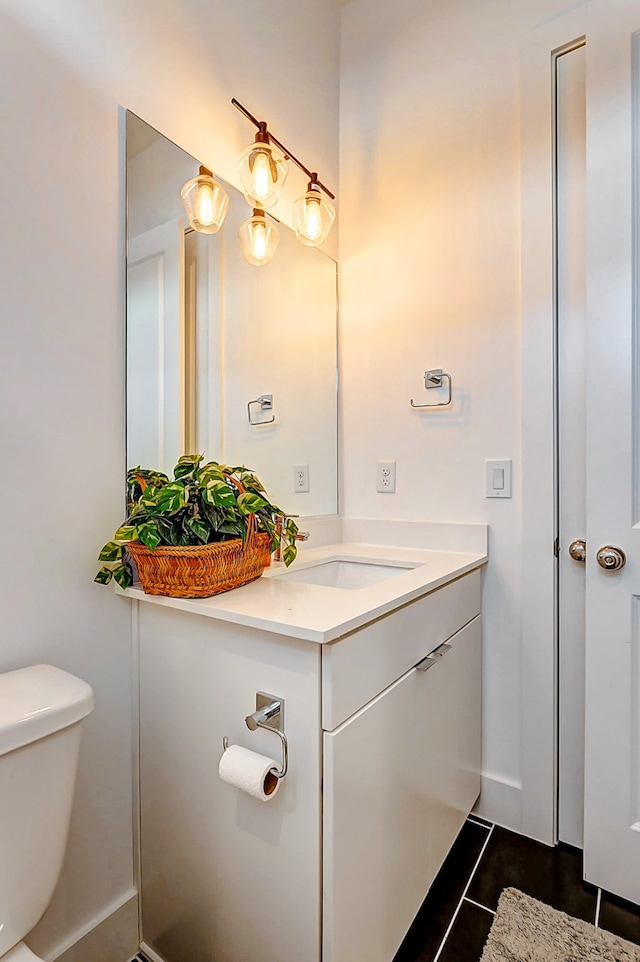 bathroom featuring tile patterned flooring, vanity, and toilet