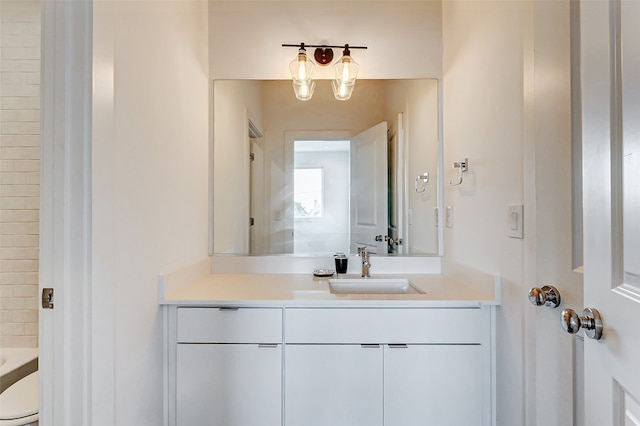 bathroom with a bathtub, vanity, and toilet