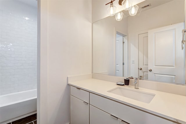 bathroom featuring tiled shower / bath combo and vanity