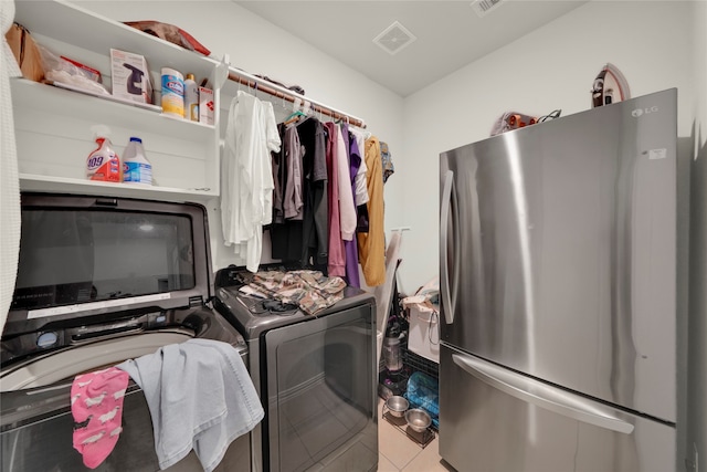 laundry area with washing machine and dryer and tile patterned flooring