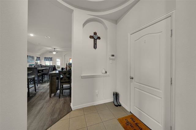 entrance foyer featuring vaulted ceiling, ceiling fan, and light tile patterned floors