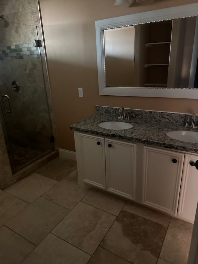 bathroom featuring tile patterned floors, a shower with door, and vanity