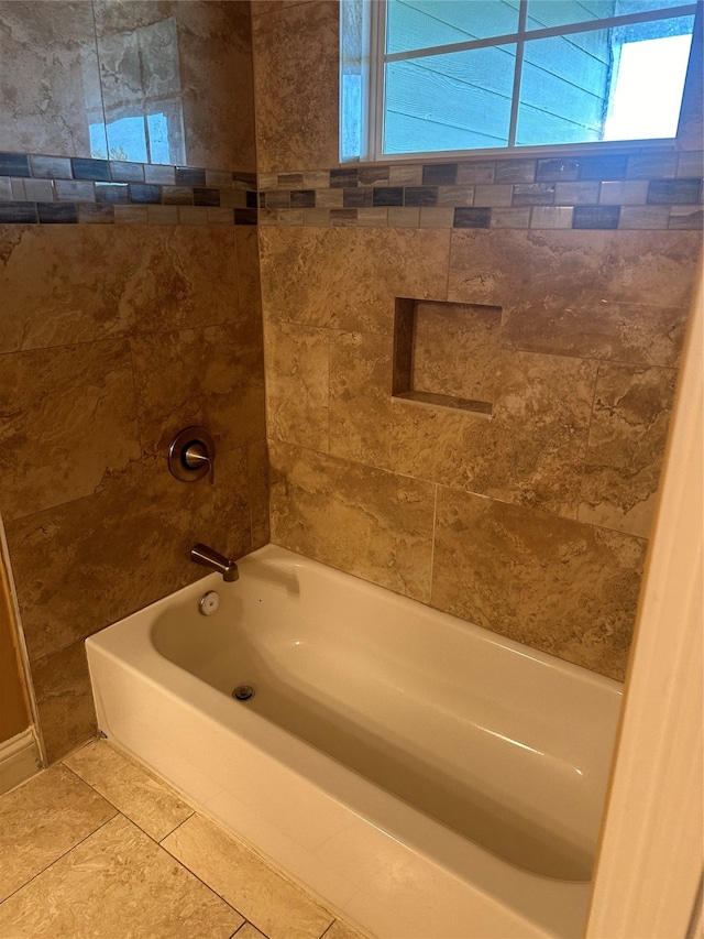 bathroom featuring tiled shower / bath combo and tile patterned flooring