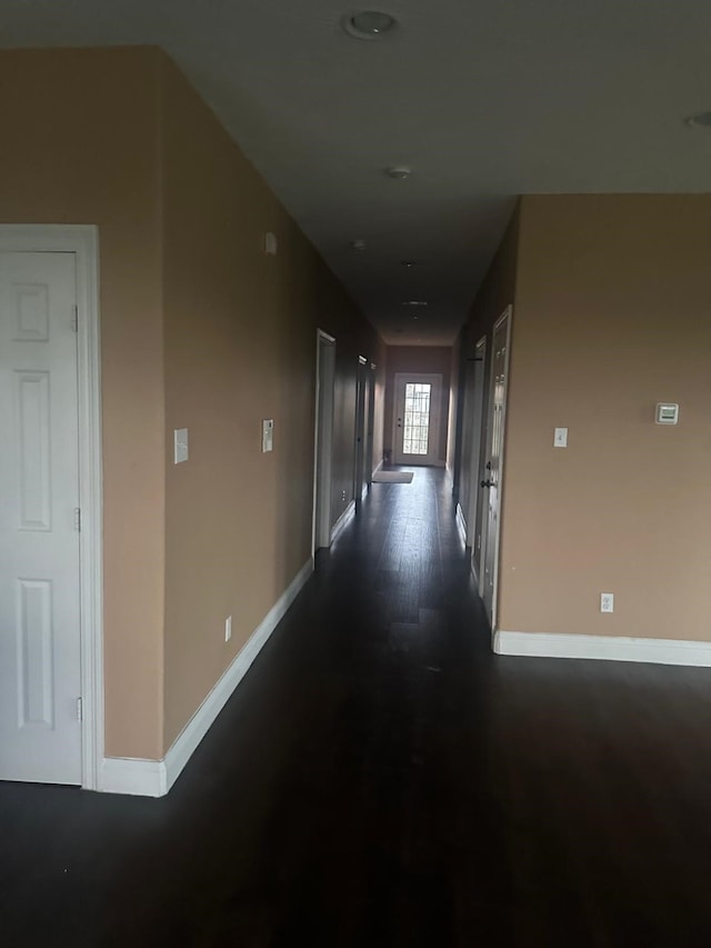 hallway with dark hardwood / wood-style flooring