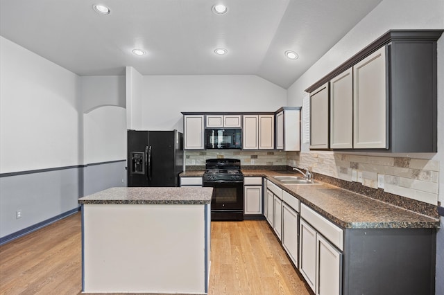 kitchen featuring lofted ceiling, tasteful backsplash, black appliances, gray cabinets, and sink