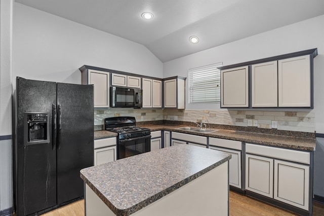 kitchen featuring gray cabinetry, black appliances, backsplash, a center island, and lofted ceiling