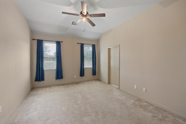 carpeted spare room featuring vaulted ceiling and ceiling fan