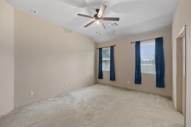 empty room featuring lofted ceiling, light carpet, and ceiling fan