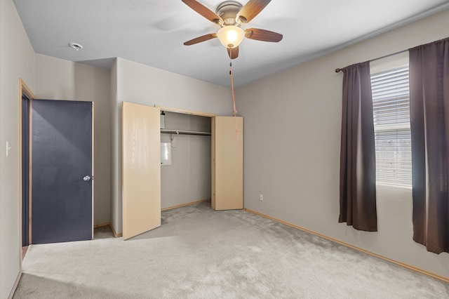 unfurnished bedroom featuring a closet, light colored carpet, and ceiling fan