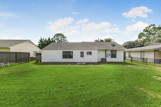 back of property featuring a lawn and cooling unit