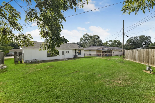 back of property featuring a lawn and cooling unit