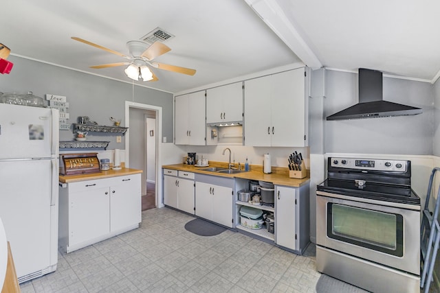 kitchen featuring white refrigerator, sink, wall chimney exhaust hood, white cabinetry, and stainless steel range with electric cooktop