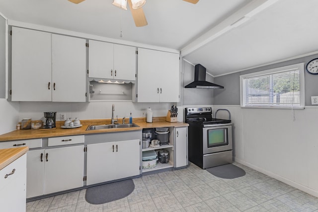 kitchen featuring white cabinetry, ceiling fan, stainless steel range with electric cooktop, sink, and wall chimney range hood