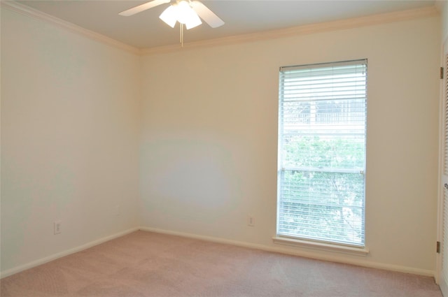 carpeted empty room featuring ceiling fan and crown molding