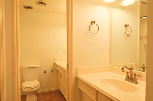 bathroom featuring vanity, tile patterned flooring, and toilet