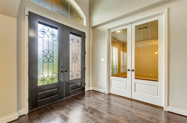 foyer entrance featuring dark wood-type flooring, french doors, and plenty of natural light