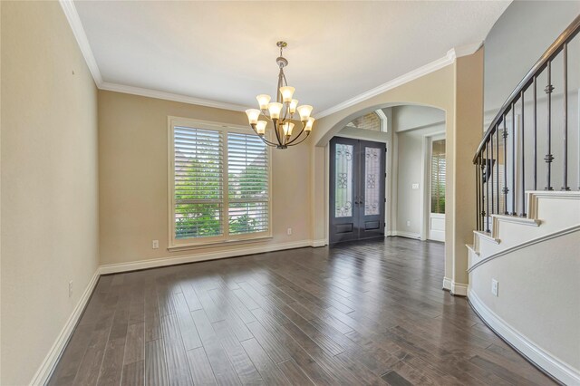 entryway with an inviting chandelier, ornamental molding, dark wood-type flooring, and french doors