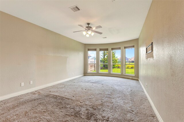 carpeted spare room featuring ceiling fan