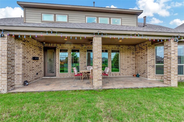 back of house featuring a lawn and a patio area