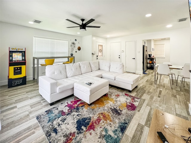 living room with light wood-type flooring and ceiling fan