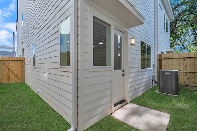 property entrance featuring a lawn and central air condition unit