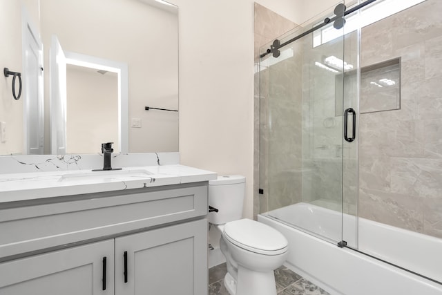 full bathroom featuring shower / bath combination with glass door, vanity, and toilet