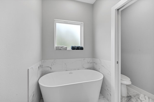 bathroom featuring toilet and a tub