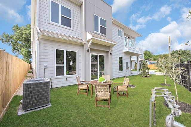 rear view of house featuring central AC and a yard