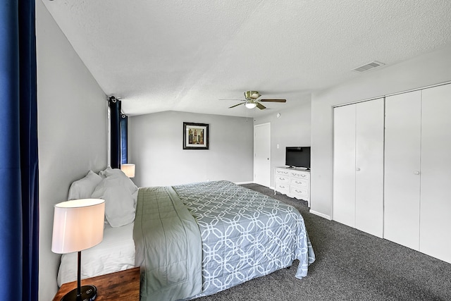 bedroom featuring a closet, dark colored carpet, ceiling fan, and a textured ceiling