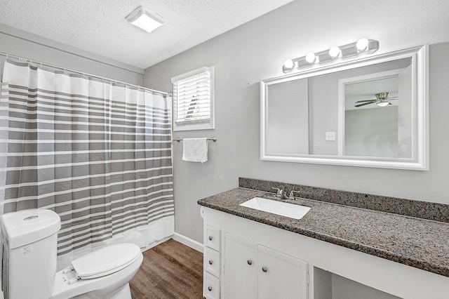 bathroom with wood-type flooring, vanity, toilet, and a textured ceiling