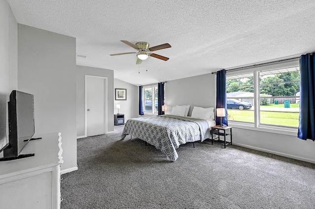 bedroom with a textured ceiling, vaulted ceiling, dark colored carpet, and ceiling fan